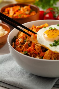 Pirinç ve tavuklu kimçi lahanası. Hafif mermer arka planda beyaz bir kasede servis edilmiş. Ön görünüm.