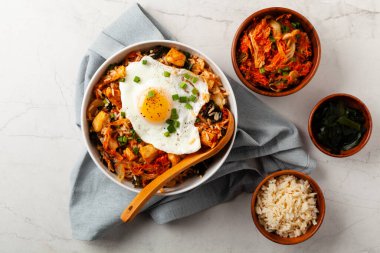 Pirinç ve tavuklu kimçi lahanası. Hafif mermer arka planda beyaz bir kasede servis edilmiş. Üst görünüm.