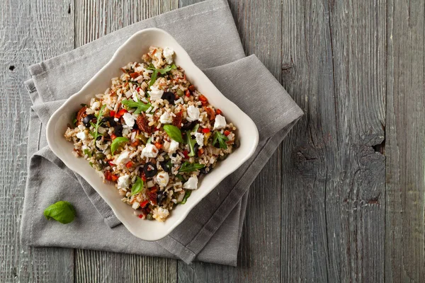 Kırmızı pirinçli moda öğle yemeği, sebze ve sebze karışımı. Üst Manzara. Gri ahşap arka planda beyaz kasede servis ediliyor.. 