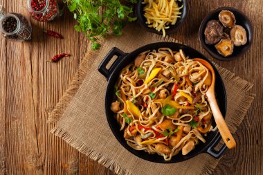 Mangolu kızarmış tavuk ve erişteli hindistan cevizi sütü. Bir tavada hazır. Üst görünüm. 