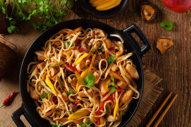 Mangolu kızarmış tavuk ve erişteli hindistan cevizi sütü. Bir tavada hazır. Üst görünüm. 