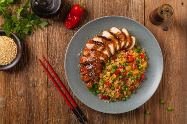 Teriyaki soslu ızgara tavuk göğsü. Kahverengi pirinç ve sebzelerle servis edilir. Üst Manzara. Düz yatıyordu.