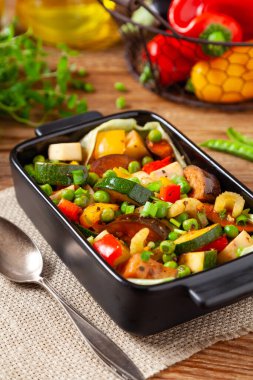 Vejetaryen yahnisi. Kızartma tavasında hazır. Doğal ahşap zemin.