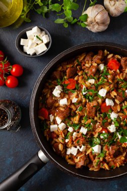 Geleneksel Yunan mutfağı. Peynirli ve sebzeli kuzu güveç. Koyu arkaplan.