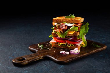 Peynirli tost ekmeği, pastırma, yumurta ve sebze. Kötü ruh hali. Siyah arkaplan.