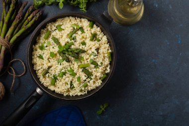 Klasik İtalyan pilavı ve kuşkonmaz. Üst Manzara. Koyu mavi arkaplan.