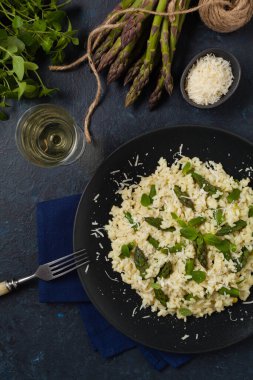 Klasik İtalyan pilavı ve kuşkonmaz. Üst Manzara. Koyu mavi arkaplan.