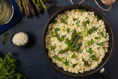 Klasik İtalyan pilavı ve kuşkonmaz. Üst Manzara. Koyu mavi arkaplan.