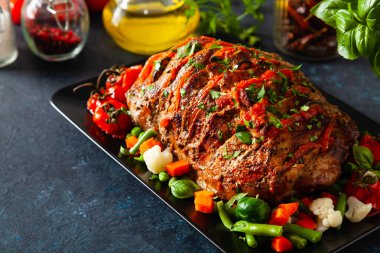 Tam kavrulmuş, domates, zeytin ve domuz boynuyla doldurulmuş. Karanlık arka plan, karanlık ruh hali.