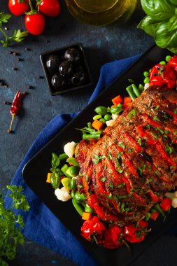 Tam kavrulmuş, domates, zeytin ve domuz boynuyla doldurulmuş. Karanlık arka plan, karanlık ruh hali.