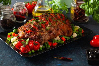 Tam kavrulmuş, domates, zeytin ve domuz boynuyla doldurulmuş. Karanlık arka plan, karanlık ruh hali.