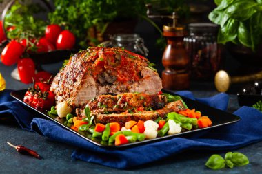 Tam kavrulmuş, domates, zeytin ve domuz boynuyla doldurulmuş. Karanlık arka plan, karanlık ruh hali.