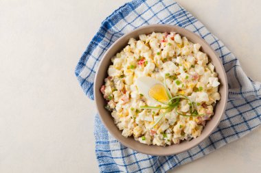 Kerevizli, turşulu, biberli ve mayonezli hafif yumurta salatası. Arka planda bir kasede servis edilmiş. Üst görünüm.