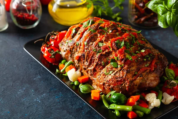 Tam kavrulmuş, domates, zeytin ve domuz boynuyla doldurulmuş. Karanlık arka plan, karanlık ruh hali.