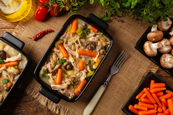 Geleneksel mantar ve sebzeli tavuk güveci. Tavuk güveci. Siyah kaplarda servis edilir..