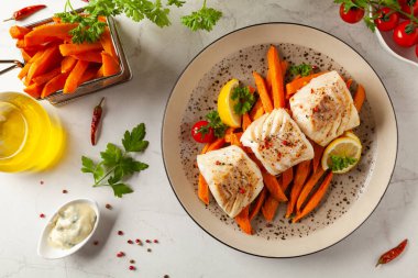 Kızarmış morina filetosu, yanında patates kızartması. Işık taşı arkaplanı. 