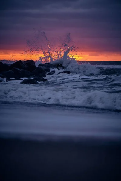 Wave crashing at the rock sin sunset — Stock Photo, Image