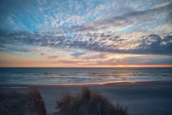 Sunset behind clouds at the north sea coast in Denmark — Foto Stock