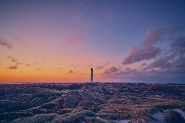 white Lighthouse at sunrise in the dunes of the danish north sea coast. High quality photo