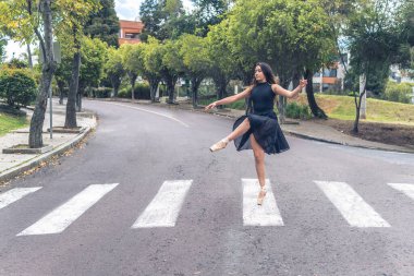 Caddede yaya geçidini geçen bir balerin figürü.