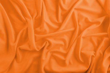 Orange textile background with wrinkles and waves