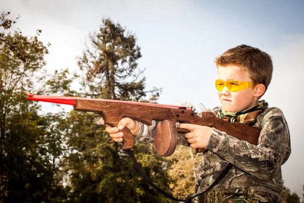 Niño jugando con juguete goma banda pistola —  Fotos de Stock