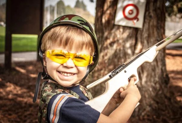 Menino brincando com brinquedo Crossbow Gun Fotografias De Stock Royalty-Free
