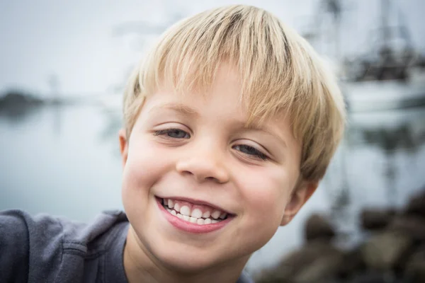 Мальчик на скалах в гавани — стоковое фото