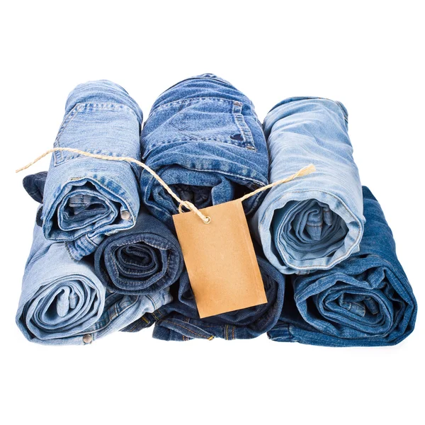 Veel verschillende blue jeans in de stapel close-up geïsoleerd op witte achtergrond — Stockfoto