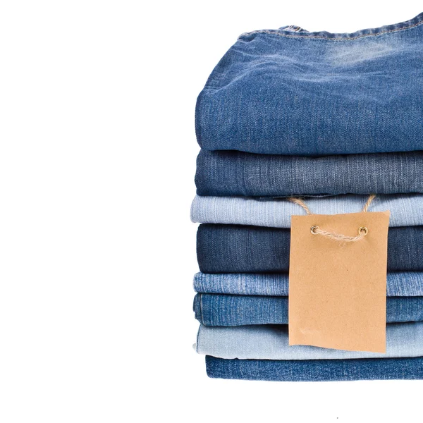 Lot of different blue jeans in the stack close-up isolated on white background — Stock Photo, Image