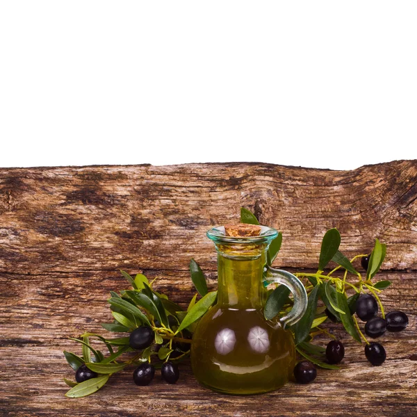 Olive oil in a small glass bottle with olive tree branches — Stock Photo, Image