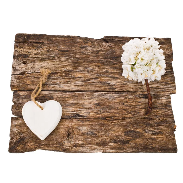Старая доска украшена белыми цветами и фигурой в форме сердца — стоковое фото