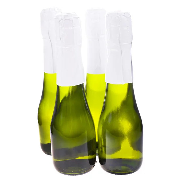Neljä vihreä pieni pullo samppanjaa ilman etiketti eristetty valkoisella pohjalla — kuvapankkivalokuva