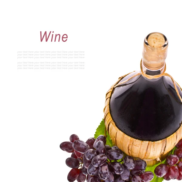 Red wine in a pot-bellied bottle with a wicker basket and grapes with drops of water isolated on white background — Stock Photo, Image