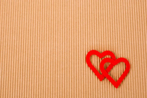 Two figures in the form of heart on the background of corrugated cardboard Royalty Free Stock Images