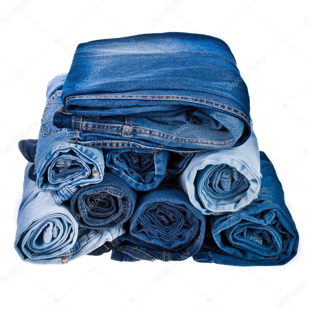 Lot of different blue jeans in the stack isolated on white background