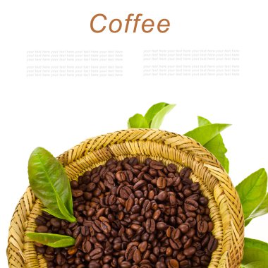 Coffee beans in a wicker basket decorated with green leaves isolated on white background