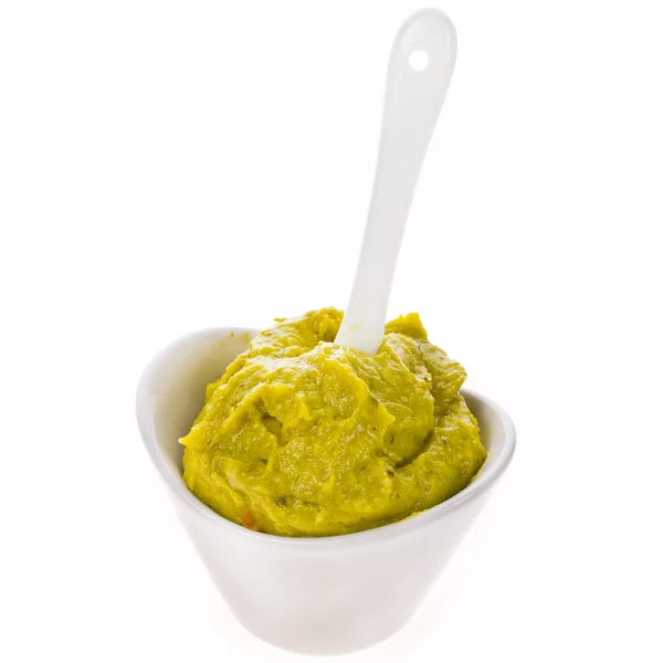 Guacamole frais dans un bol blanc avec une cuillère isolée sur fond blanc — Photo