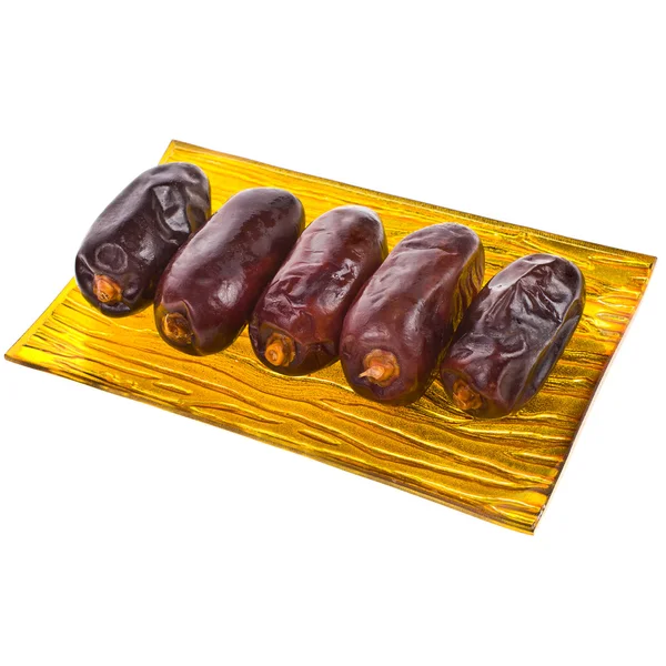 Large fresh dates on a gold plate isolated on white background — Stock Photo, Image