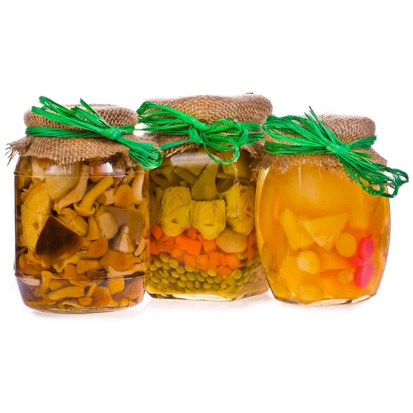 Tres frascos de vidrio con conservas, champiñones en escabeche, verduras y frutas guisadas — Foto de Stock