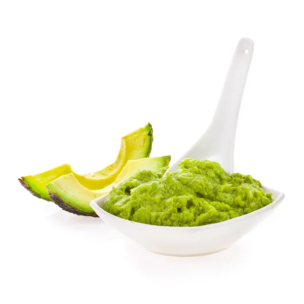 Fresh guacamole in a white bowl with a spoon — Stock Photo, Image