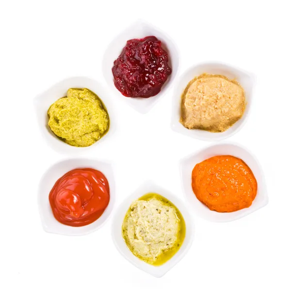 Six sauces différentes dans un bol blanc avec cuillères — Photo