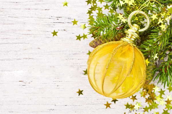 Branch of Christmas tree and big gold Christmas ball — Stock Photo, Image