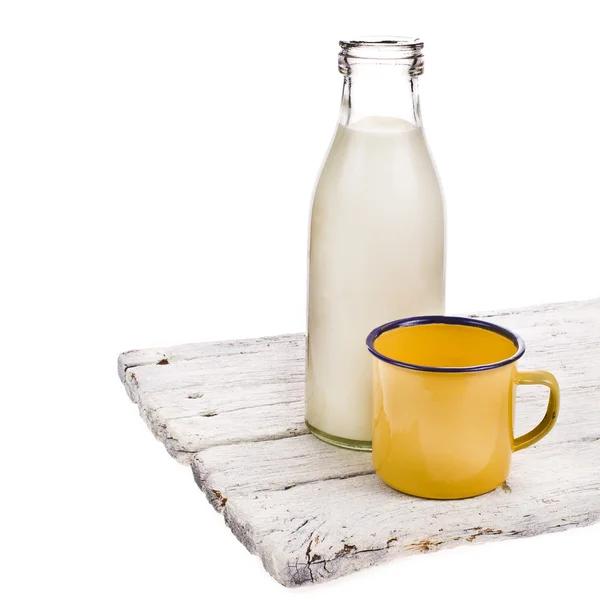 Alte Glasflasche voller Milch und gelbem Emaille-Becher — Stockfoto