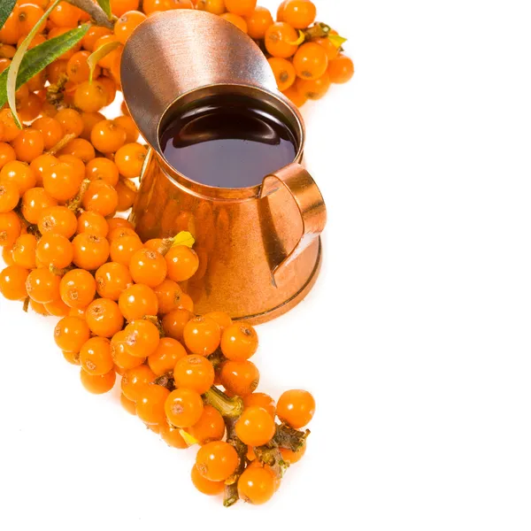 Small brass pitcher with sea buckthorn oil — Stock Photo, Image