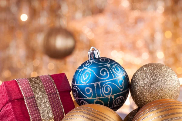 Goldene und blaue Christbaumkugeln und rote Schachtel — Stockfoto