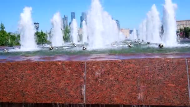 在摩天大楼和无云蓝天的背景下喷出的喷泉. — 图库视频影像