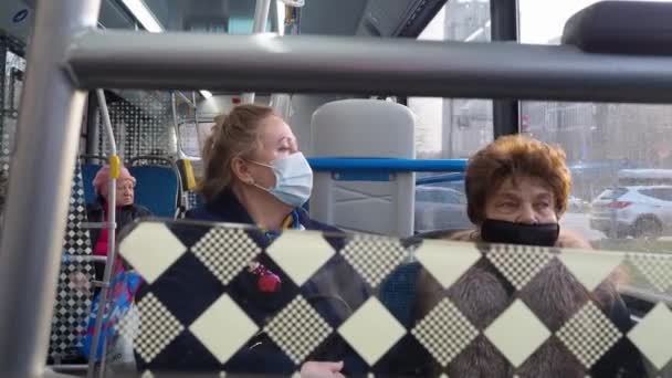 Zwei ältere Frauen in medizinischen Schutzmasken in einem Stadtbus. — Stockvideo