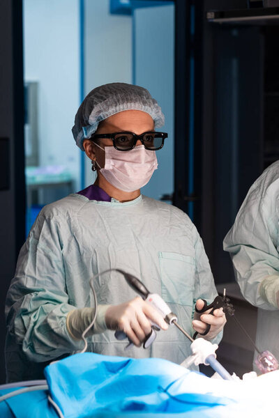 Женщина-хирург в 3D очках делает лапароскопическую операцию