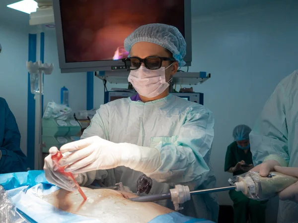 Женщина-хирург в 3D очках вставляет инструмент в тело пациента — стоковое фото